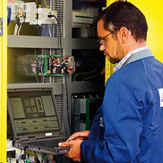 Man using a laptop to perform steel belt damage root cause analysis